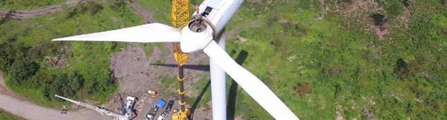 Photo of a crane installing a wind mill