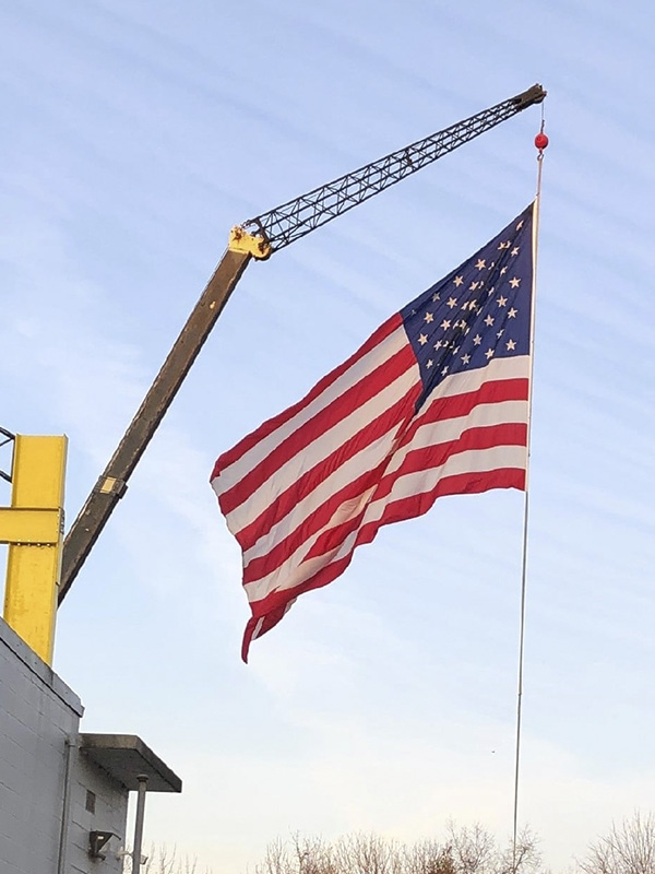 Photo of an American Flag hanging from a crane